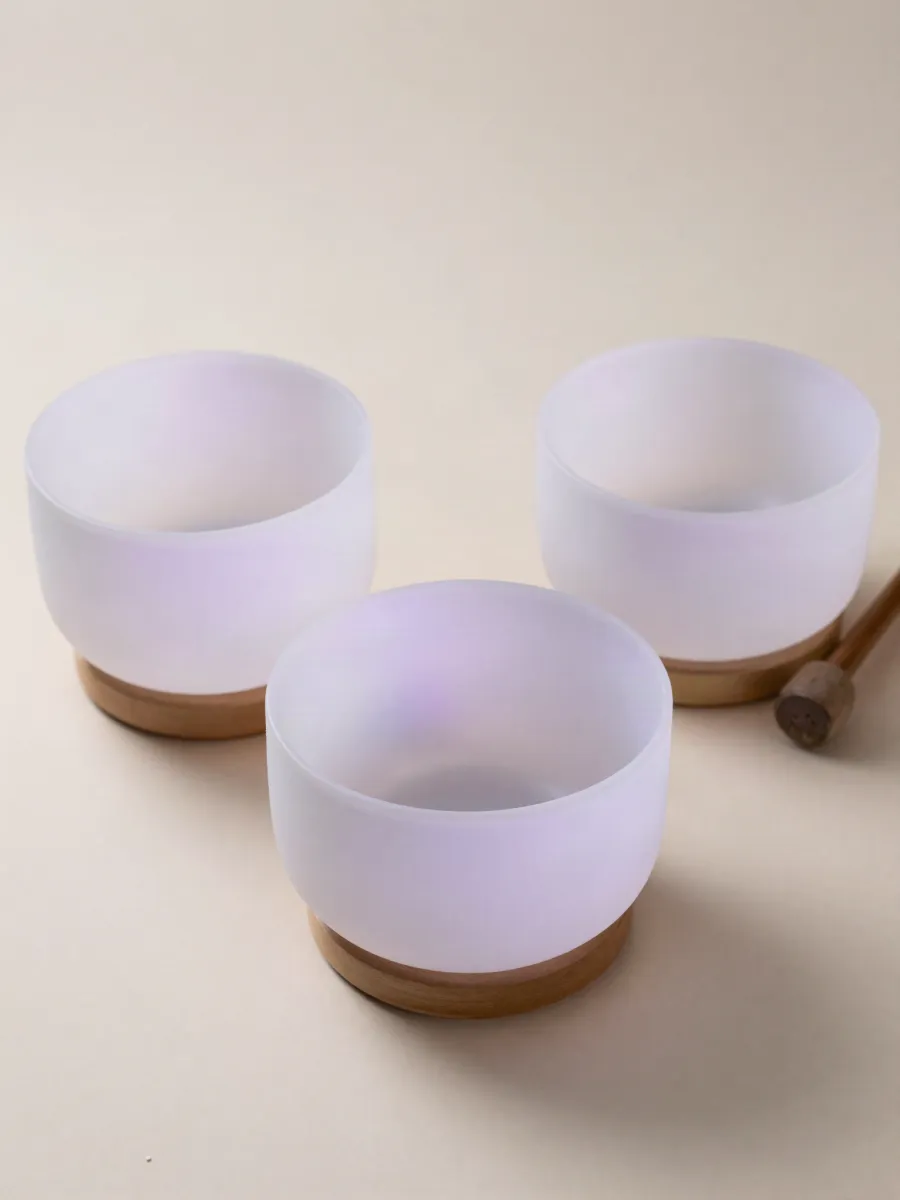 Frosted crystal singing bowls on an ivory surface